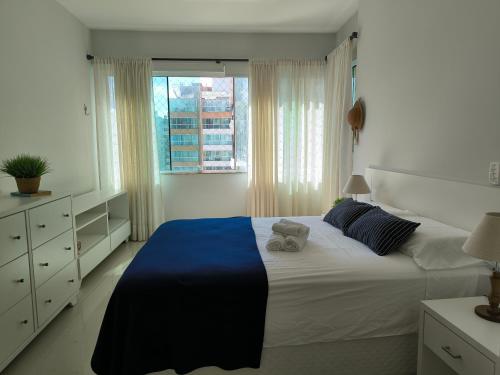 a bedroom with a large bed and a window at Apartamento uma quadra do mar, melhor localização in Capão da Canoa