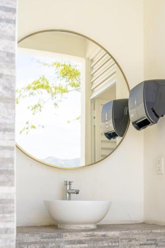 a bathroom with a round mirror and a sink at Your Perfect Getaway in Acapulco in La Sabana