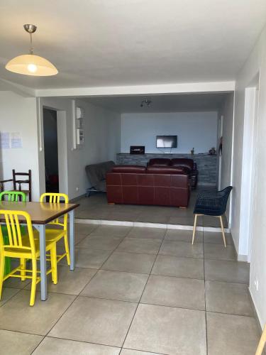 a living room with a couch and a table and chairs at Maison reposante in Le Tampon