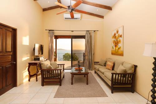 a living room with a couch and a ceiling fan at Luxury Flamingo villa with outdoor bar - pool and magnificent views in Playa Flamingo