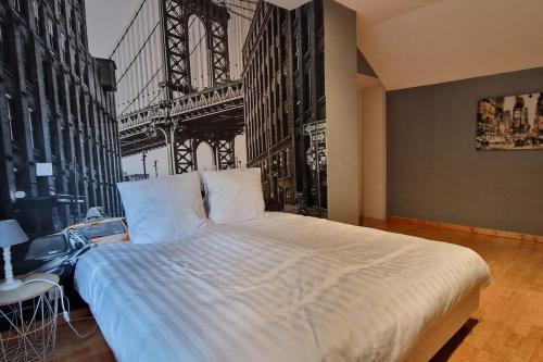 - une chambre avec un grand lit en face d'un pont dans l'établissement Maison Montoise, à Mont-Saint-Sulpice
