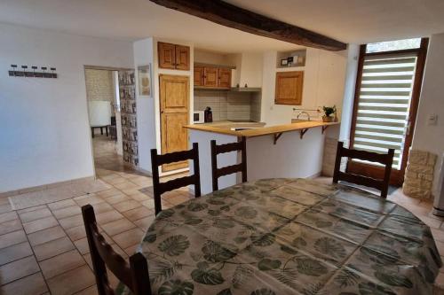 une cuisine et une salle à manger avec une table et des chaises dans l'établissement Maison Montoise, à Mont-Saint-Sulpice