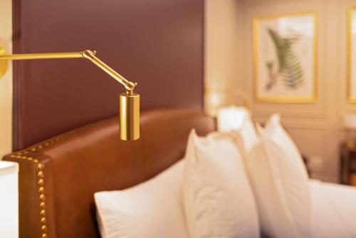 a lamp over a bed with white pillows at Sinclair Suites - Stylish Retro Boutique Hotel in West Dundee