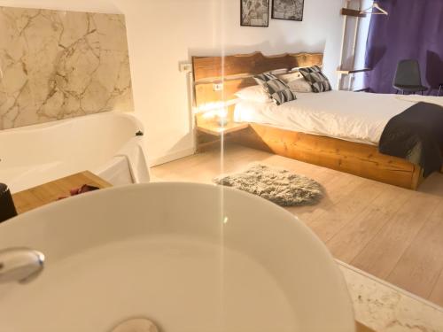 a bathroom with a tub and a bedroom with a bed at MiddleHouse in Braşov