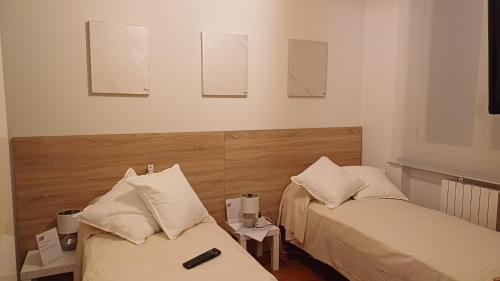 2 Betten in einem kleinen Zimmer mit in der Unterkunft Appartamento 93 di andrea sonzogni in Castelleone