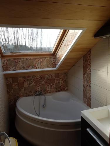 une salle de bain avec une baignoire et une fenêtre dans l'établissement Chalet Ecrin équipé pour Personne à Mobilité Réduite, Belle vue lac, Sauna et Wifi, à Gérardmer