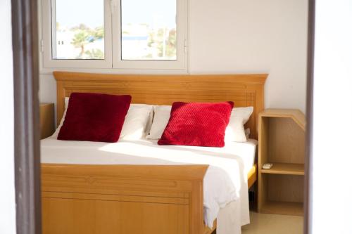 塔格梅斯Spacious 2-Floor Apt in Lavandolive Residence的一间卧室，床上有两个红色枕头