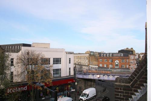 a view of a city with buildings and a truck at Cosy 3 Bedroom Flat, Hackney Central in London