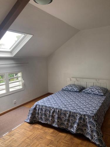 a bedroom with a bed with a blue comforter and two windows at Maison reposante in Le Tampon