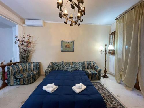 a living room with a blue bed and a couch at Iolly's House in Livorno