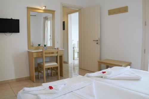 a bedroom with two beds and a desk and a mirror at Theologos Beach in Antiparos Town