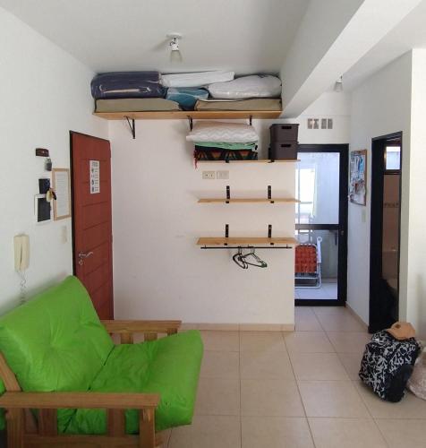 a living room with a green chair and stairs at DIVINO Colon 1 in Colón