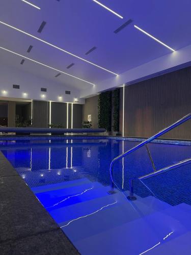 a swimming pool with blue lights in a building at BOREMEL HILLS in Boremelʼ