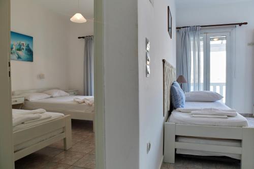 a bedroom with two beds and a mirror at Theologos Beach in Antiparos Town