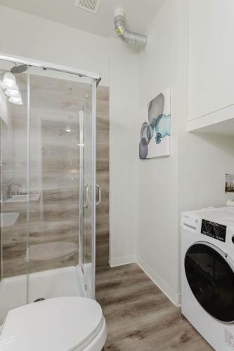 a bathroom with a toilet and a glass shower at 2BR Modern Retreat Near Henry Ford in Detroit