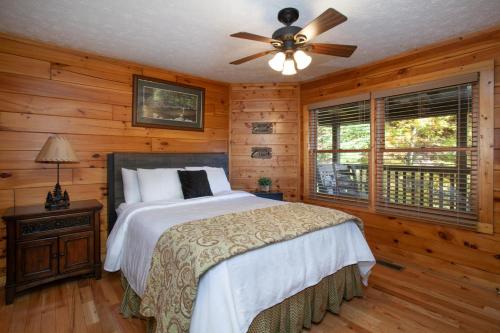 a bedroom with a bed and a ceiling fan at Bears Corner w/ Hot Tub, Arcade & Community Pool! in Gatlinburg
