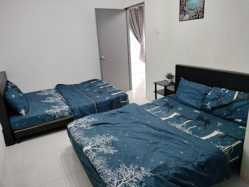two beds with blue sheets in a bedroom at Ammara Homestay 2 Emerald Avenue Brinchang in Brinchang