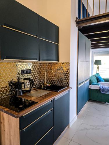 a kitchen with dark blue cabinets and a sink at PIOTROWSKI APARTMENTS in Theológos