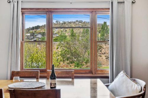 a dining room with a table and a large window at Cascade Cottage adjoining World Heritage Site in Hobart