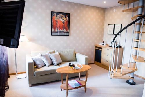 a living room with a couch and a table at Nynäsgården Hotell & Konferens in Nynäshamn