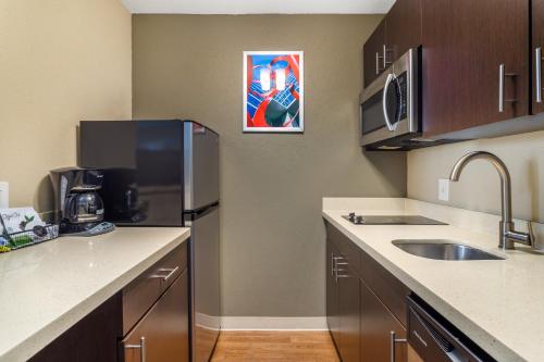 a small kitchen with a sink and a refrigerator at MainStay Suites Houston NASA-Clear Lake in Webster