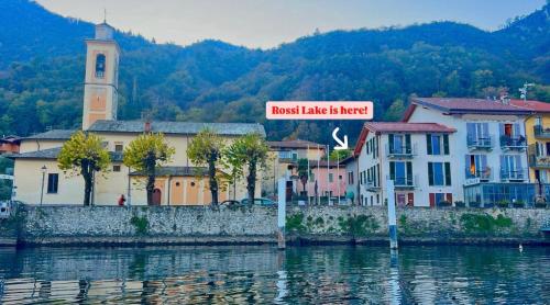 a street sign in a town next to a body of water at Rossi Lake Couple in Oliveto Lario