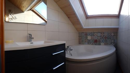 une salle de bain avec un lavabo et une baignoire dans l'établissement Chalet Eras, Belle vue lac, Sauna, Wifi, à Gérardmer