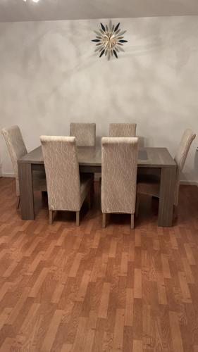 une salle à manger avec une table et des chaises en bois dans l'établissement Appartement 2 chambres et salon proche Paris, à Sèvres
