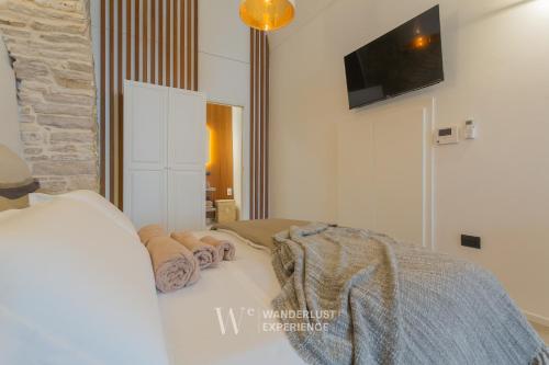 a bedroom with a bed and a tv on a wall at Wanderlust Experience White Cave in Bitonto