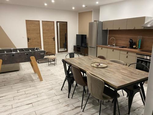 - une cuisine avec une table de ping-pong et des chaises dans l'établissement Charmante Maison Wicroise, à Wicres