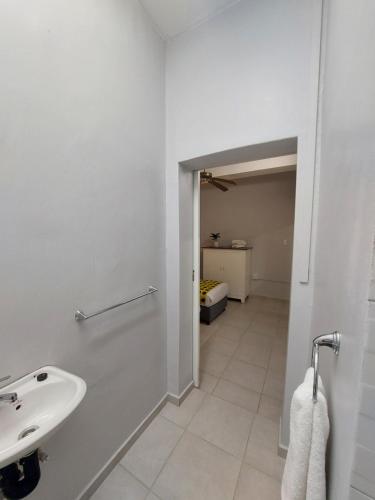 a white bathroom with a sink and a hallway at Fairway Guest Lodge in Margate