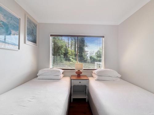 two twin beds in a room with a window at Pet-Friendly 2-Bed Beach House with Garden & BBQ in Surf Beach