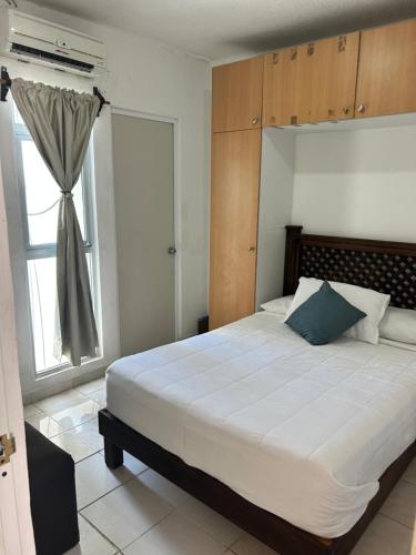 a bedroom with a large bed and a window at Departamento 5 Economico Arroyo in Tuxtla Gutiérrez