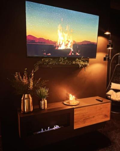 a living room with a television with a fire on the screen at MOON ROOM - privátní wellness in Chrudim