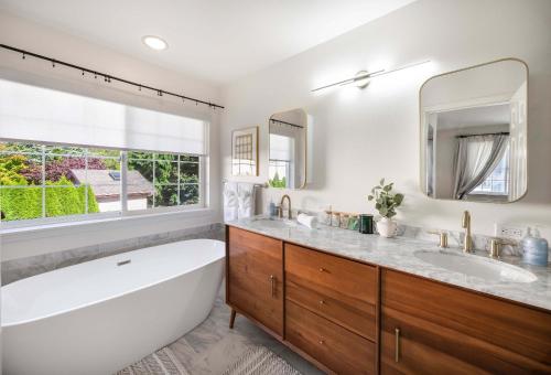 a bathroom with a tub and a sink and a mirror at Kirkland Elegant 4B 2 5B Family Retreat with Designer Decor in Kirkland