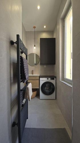 - une buanderie avec un lave-linge et un miroir dans l'établissement Luxueux T3 aux portes de Monaco, à Beausoleil