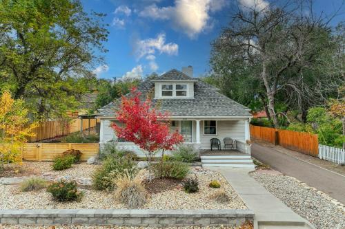 a white house with a red tree in a yard at Bristhol Bloom! Oasis in the Heart of COS! in Colorado Springs