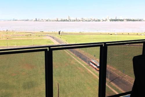 a view of a field from a fence with a train at Alojamiento en Departamento de Lujo in Encarnación