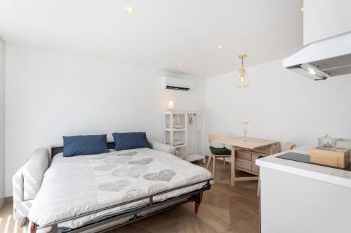 une chambre blanche avec un lit et un bureau dans l'établissement Appartement ESCAPADE BIEN ETRE & DECONNEXION, à Roumens