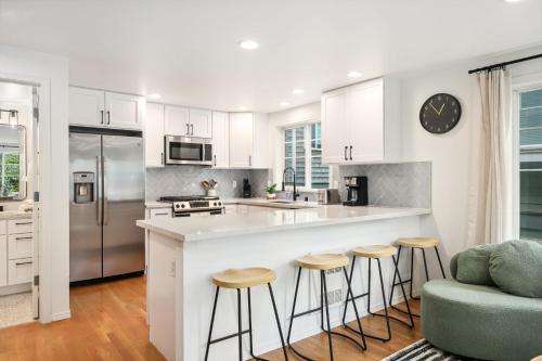 a kitchen with white cabinets and a counter with stools at Green Lake Remodelled home with AC garage yard in Seattle