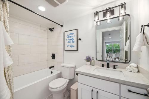 a white bathroom with a toilet and a sink at Green Lake Remodelled home with AC garage yard in Seattle