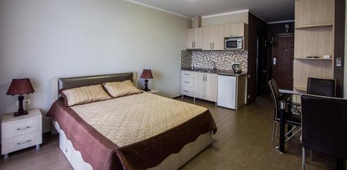 a bedroom with a large bed and a kitchen at My Batumi Apartments in Batumi