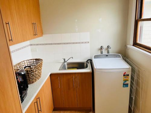 een kleine keuken met een spoelbak en een koelkast bij Saltwater Bungalow - WiFi in Robe