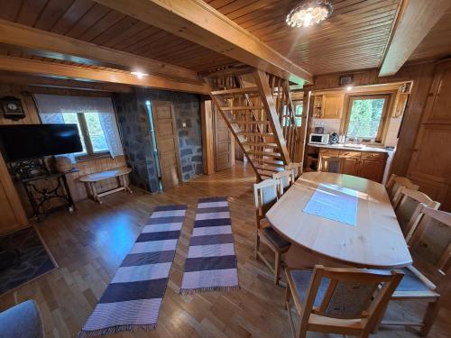 a dining room with a table and a staircase in a cabin at Nagy Lak I. in Sub Cetate