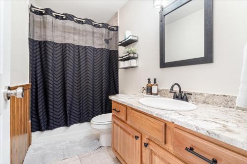 a bathroom with a sink and a shower curtain at Beautiful 3 bed 2 bath home near Crystal Bridges in Bentonville