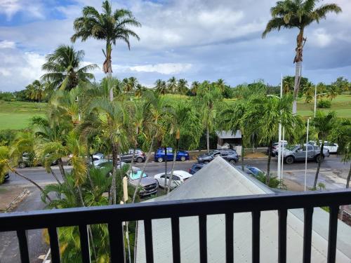Elle comprend un balcon donnant sur un parking avec des palmiers. dans l'établissement Ti gecko, à Saint-François