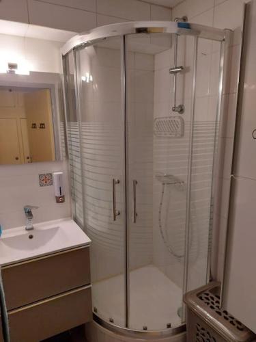 une salle de bain avec douche et lavabo dans l'établissement Appartement à 2 pas de la mer, à Canet
