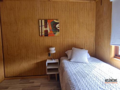 a bedroom with a bed and a picture on the wall at Ruka Lee I Las Trancas - Refugios de Montaña Reloncaví - Factura Inmediata in Las Trancas