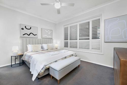 a white bedroom with a bed and a window at Dalton Cottage - Charm & Convenience in Orange