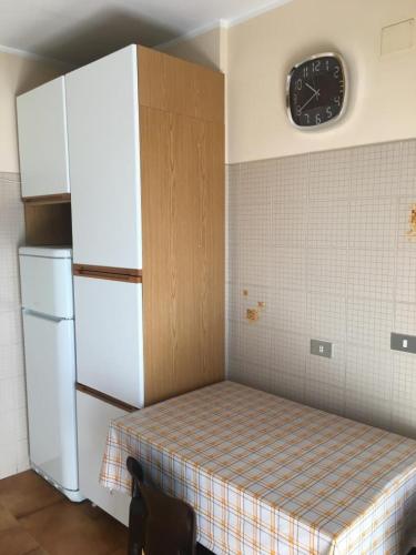 a kitchen with a bed and a clock on the wall at Viale Ancona by Ospitaci in Foligno